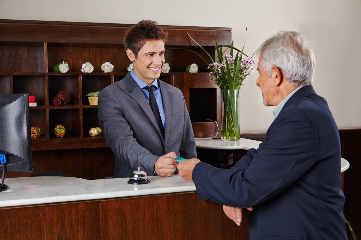 A hotel employee handing a key to a businessman